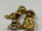 two gold birds that are sitting on a white surface