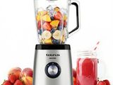 a blender with fruit in it next to a jar of smoothie