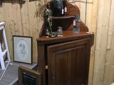 a wooden cabinet with a vase on top of it in a room