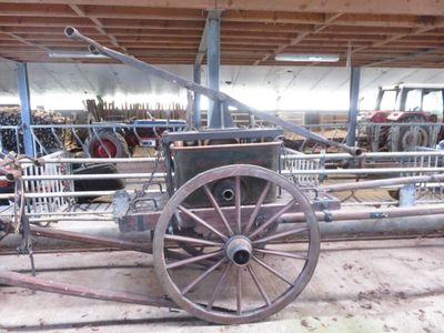 a horse pulling a cart inside of a barn