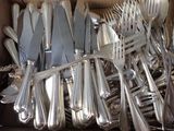 a lot of silverware in a box on the table
