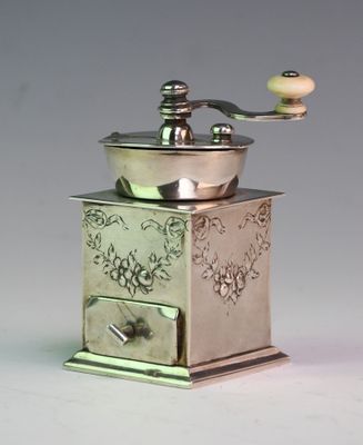 a silver coffee grinder sitting on top of a table