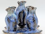 three blue vases sitting on a tray on a white surface
