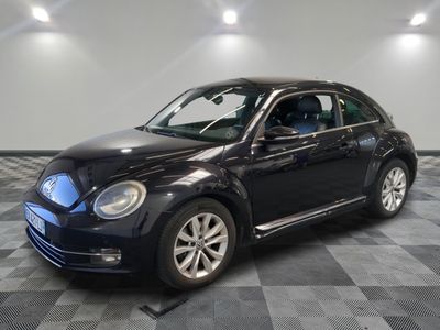 a picture of a black volkswagen beetle parked in a garage