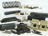 beaucoup de rails et d'accessoires de train miniature sur la table