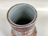 a small vase that is sitting on a white surface