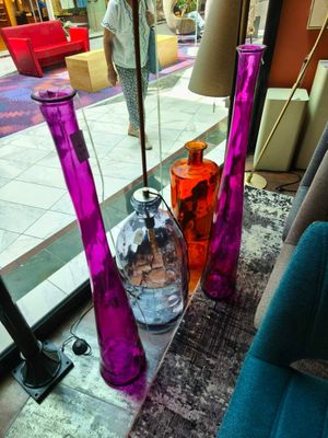 trois vases posés sur une table devant une fenêtre