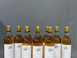 six bouteilles de vin sont alignées sur une étagère devant une source de lumière