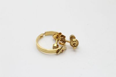 l'image d'une paire de boucles d'oreilles en or sur une surface blanche