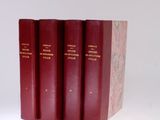 three red books sitting on top of each other on a white surface