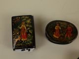 a small box with a painting on it next to a smaller box with a painting on it