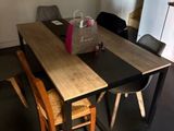 a table and chairs in a room with a refrigerator in the background