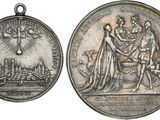 two silver medals with a picture of a man and a woman on them