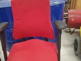a red office chair sitting in front of a blue barrel