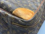 un gros plan d'un sac Louis Vuitton posé sur une surface bleue
