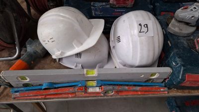 two hard hats sitting on top of a work bench