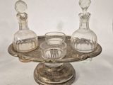 a silver tray with three glass decanters and a glass decanter