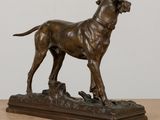 bronze statue of a dog standing on a rock on a table