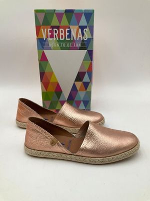 une paire de pantoufles métallisées pour femme, avec une boîte en arrière-plan