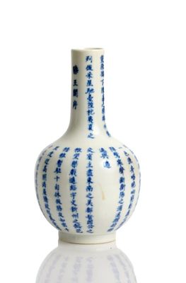 un vase bleu et blanc posé sur une surface blanche