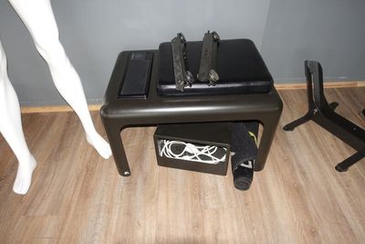 une petite table sur laquelle est posé un ordinateur portable, à côté d'un mannequin