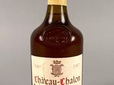 une vieille bouteille de vin de Château-Chalon posée sur une table