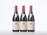 three bottles of red wine sitting on top of a white table