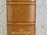 un livre en cuir marron posé sur une table blanche