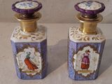 une paire de flacons de parfum violets et dorés ornés d'illustrations représentant des femmes