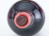 close up of a bottle of wine with a red cap