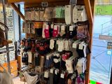 une femme debout dans un magasin, en train de regarder un présentoir de vêtements