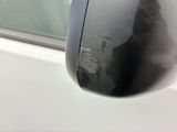 a reflection of a person in the side view mirror of a car
