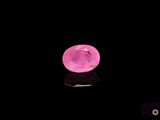 gros plan d'un diamant rose sur une surface noire