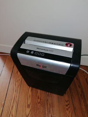 a black and silver paper shredder sitting on a hard wood floor