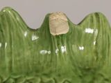 a green vase that has a small rock in it