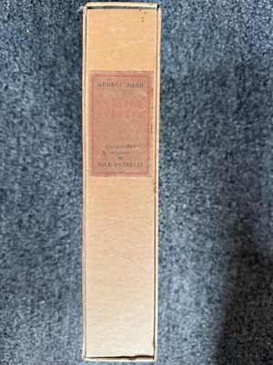 an old book sitting on top of a blue cloth covered floor