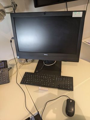 un bureau d'ordinateur équipé d'un écran, d'un clavier, d'une souris et d'un téléphone