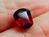 quelqu'un tient un diamant rouge à la main, passé à un doigt