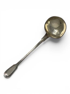 an antique silver spoon with a spoon handle on a white surface