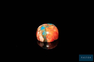 une bille orange et bleue posée sur une surface noire