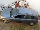 a car that is sitting in the grass next to a pile of trash