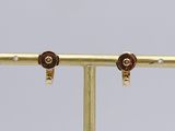pair of gold plated earrings on a gold plated stand