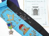 un ruban bleu orné d'un motif, à côté d'un livre