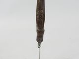 a wooden carving of a man holding a knife in his right hand