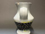 a white vase with a black and yellow design on it