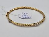 a close up of a gold bracelet with a tag on it