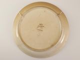 a white plate with a gold rim sitting on a table