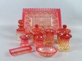 de nombreux objets en verre rose posés sur la table