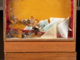 a small wooden box with a paper boat inside of it