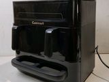 a black coffee machine sitting on a counter with a cup of coffee